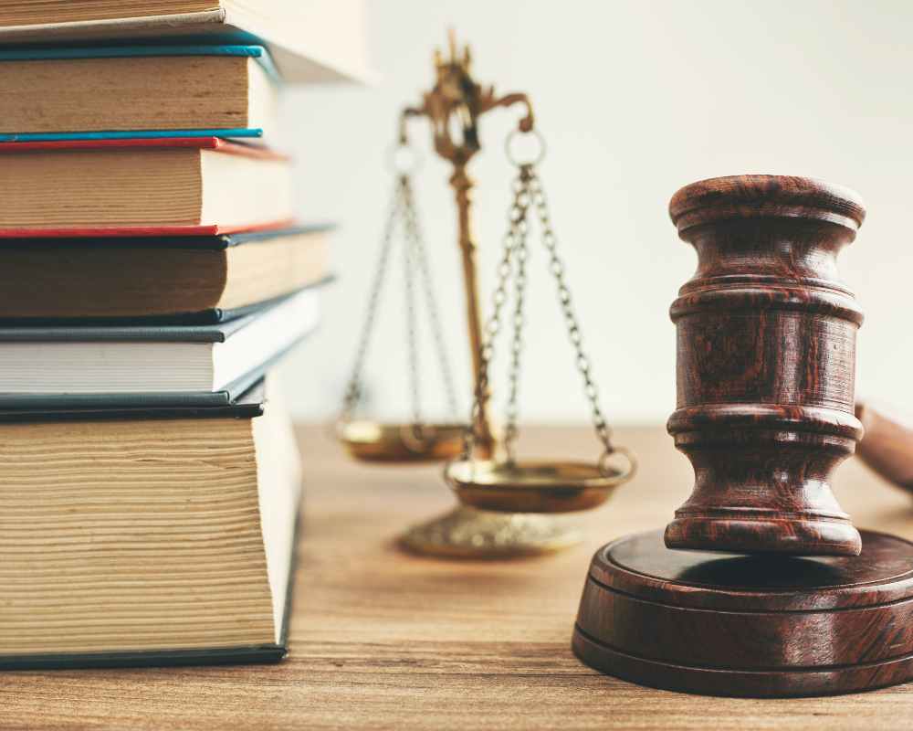 Image of a gavel, a stack of books and the scales of justice on a desk